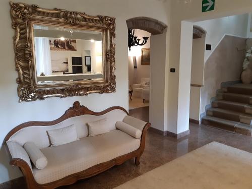 a living room with a couch and a mirror at Hotel Tirreno in Castiglioncello
