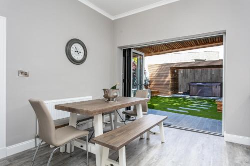 a dining room with a wooden table and chairs at The Alexander - Donnini Deluxe in Prestwick