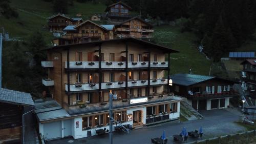 a large building with balconies on the side of a hill at Hotel Alpenblick Mürren in Mürren
