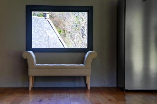 a chair sitting in a room with a window at La Dormeuse du Val in Chambon-sur-Lac