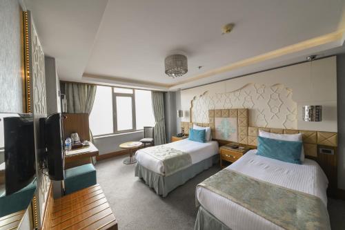 um quarto de hotel com duas camas e uma televisão em Style Star Hotel Cihangir em Istambul