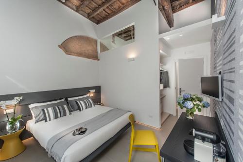 una camera con un grande letto e una sedia gialla di B&B First Floor a Roma