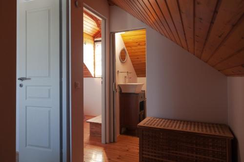 a bathroom with a sink and a hallway with a stairway at Vartan's Summer House in Kalamaki