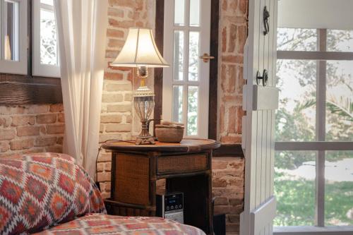 Un dormitorio con una mesa con una lámpara. en Vartan's Summer House, en Kalamaki