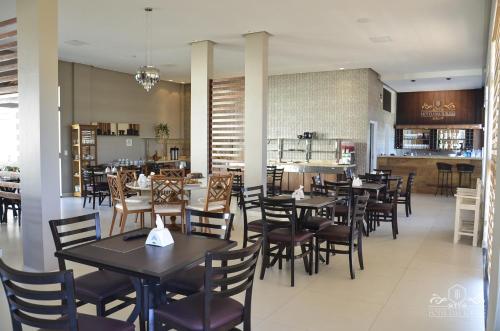 a dining room with tables and chairs in a restaurant at Hotel das Torres in Guanambi