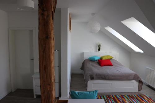 ein Schlafzimmer mit einem Bett mit bunten Kissen darauf in der Unterkunft Apartments Rischmühle in Emmerthal