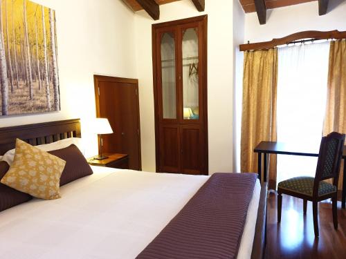 a bedroom with a bed and a desk and a chair at Hotel Segles - Turismo de Interior in Campos