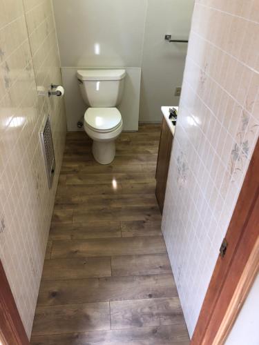 a bathroom with a toilet and a wooden floor at Sequoia National Forest CabinK in Panorama Heights