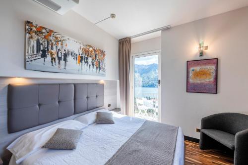 a bedroom with a large bed and a large window at Hotel Asnigo in Cernobbio