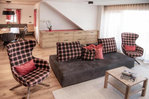 a living room with a couch and two chairs at Penthouse Chalet Pichlerhof in Brunico