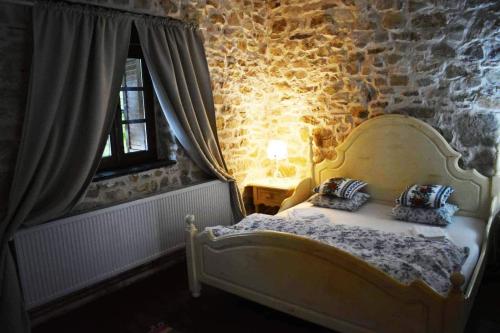 a bedroom with a bed in a stone wall at Casa Thea Cheile Nerei in Socolari
