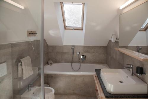 a bathroom with a tub and a sink and a shower at Penthouse Chalet Pichlerhof in Brunico