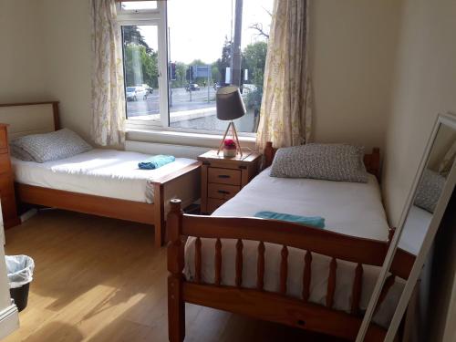 two beds in a room with a window at Tisara Guest House in Galway