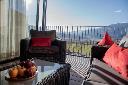 a balcony with a chair and a bowl of fruit on a table at Penthouse Chalet Pichlerhof in Brunico