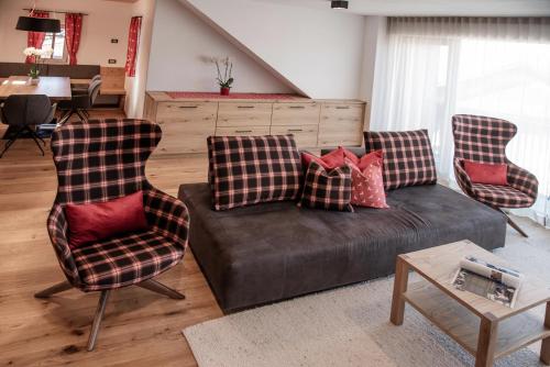 a living room with a couch and two chairs at Penthouse Chalet Pichlerhof in Brunico