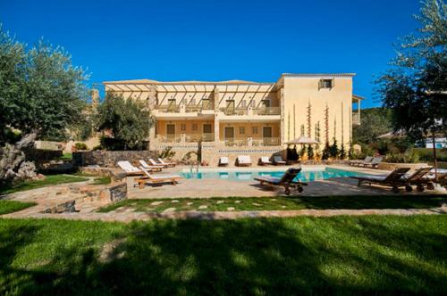 a large building with a pool in front of a house at Eleonas Studios in Poros