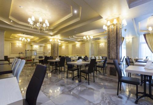 a restaurant with tables and chairs in a room at Sun Palace Gagra in Gagra