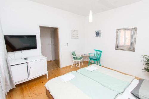 Zimmer mit 2 Betten, einem TV und einem Tisch in der Unterkunft Apartments and Rooms Ille in Šibenik
