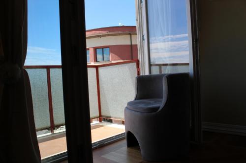 a chair sitting in front of a window at Accademia Apartment in Sassari