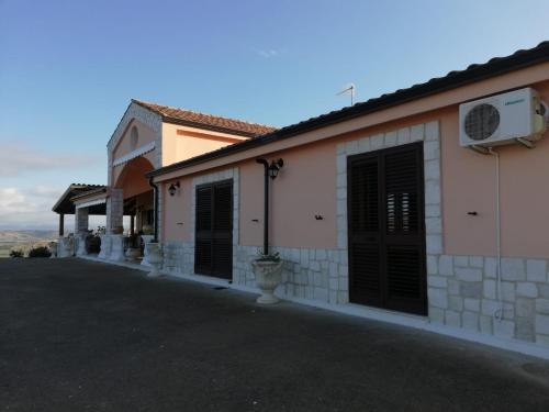 a building with black doors on the side of it at La valle degli dei in Eraclea Minoa