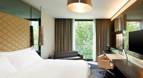 a hotel room with a bed and a desk and a tv at Excelsior Hotel Gallia, a Luxury Collection Hotel, Milan in Milan