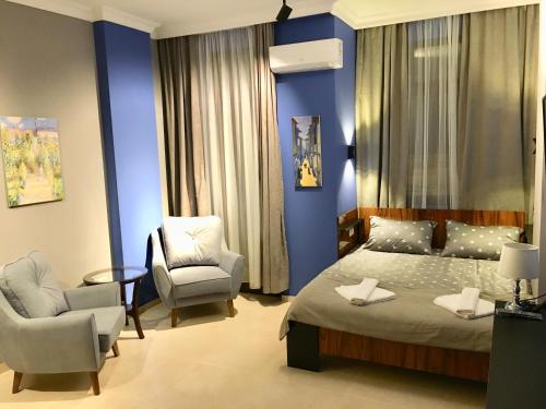 1 dormitorio con 1 cama, 2 sillas y sofá en Hotel Belvedere en Batumi
