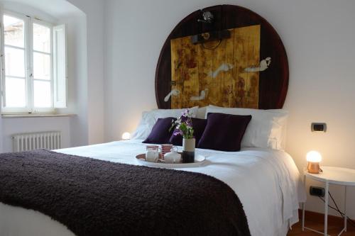 a bedroom with a large bed with a tray with flowers on it at Montalcino Loft in Montalcino