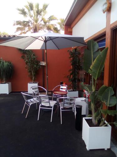 a patio with a table and chairs and an umbrella at Hotel Iris La Eliana in La Eliana