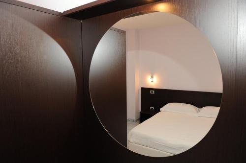 a bedroom with a bed and a round mirror at Country House Il Papavero in Bagnoli Irpino