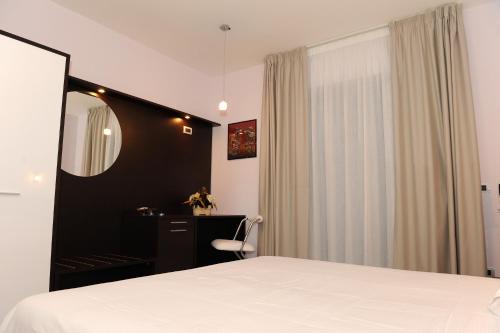 a bedroom with a bed and a desk and a mirror at Country House Il Papavero in Bagnoli Irpino