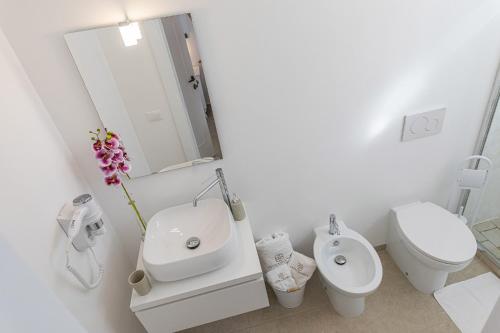 a white bathroom with a sink and a toilet at Petra Bianca in Torre San Giovanni Ugento