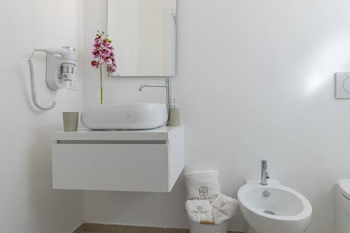 a white bathroom with a sink and a toilet at Petra Bianca in Torre San Giovanni Ugento