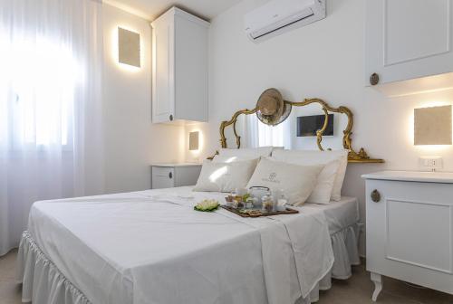 a white bedroom with a white bed with a tray on it at Petra Bianca in Torre San Giovanni Ugento