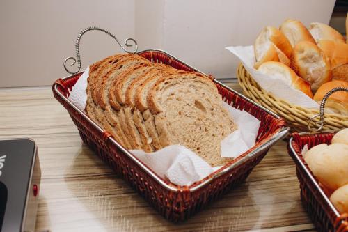 two baskets of bread and rolls and a basket of bread at Samir Hotel Business in Porto Velho