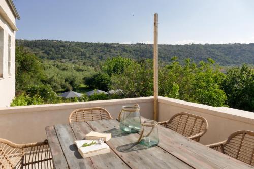 a wooden table on a balcony with a table and chairs at Boutique Villa Kalliope in Gavalochori