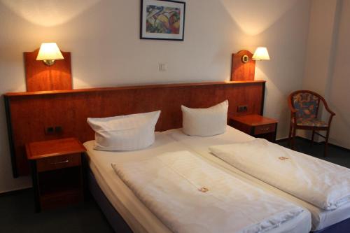 a bedroom with a large white bed with two night stands at Hotel Zeil in Frankfurt/Main