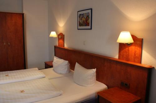 a hotel room with two beds and two lamps at Hotel Zeil in Frankfurt/Main