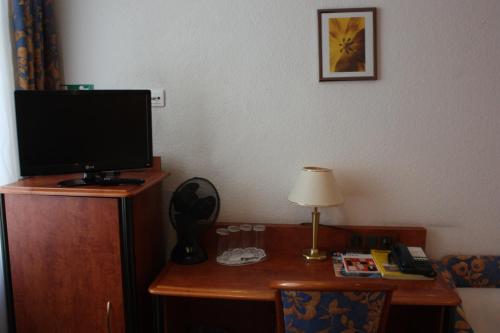 a room with a desk with a television and a lamp at Hotel Zeil in Frankfurt/Main