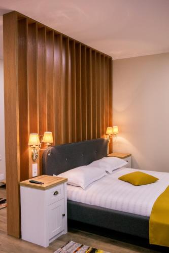 a bedroom with a bed with a wooden wall at Casa Claudia in Sîngeorgiu de Pădure