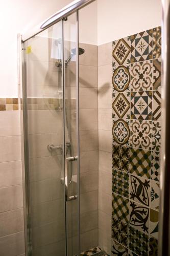 a shower with a glass door in a bathroom at Casa Claudia in Sîngeorgiu de Pădure