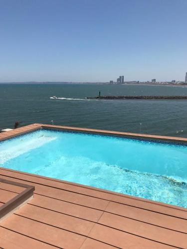 a swimming pool on a deck next to the water at FRENTE PLAYA vista al mar, PISCINA DE USO EXCLUSIVO in Boca del Río