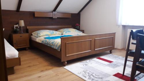 Schlafzimmer mit einem Bett mit einem Kopfteil aus Holz in der Unterkunft Pansion Brda in Rohrendorf bei Krems