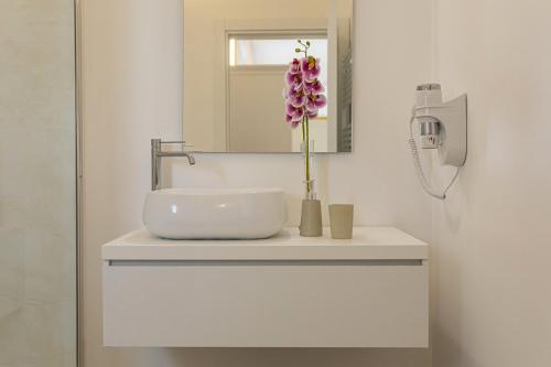 a bathroom with a sink and a vase with a flower at Petra Bianca in Torre San Giovanni Ugento