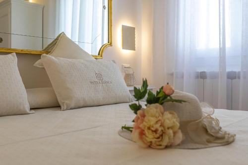a bouquet of flowers sitting on top of a bed at Petra Bianca in Torre San Giovanni Ugento