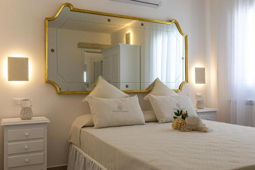 a bedroom with a large mirror above a bed at Petra Bianca in Torre San Giovanni Ugento