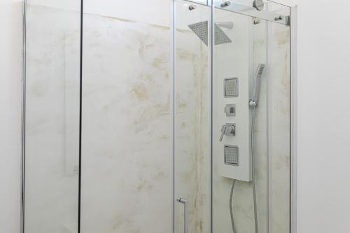 a shower with a glass door in a bathroom at Petra Bianca in Torre San Giovanni Ugento