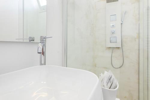 a white bathroom with a shower and a sink at Petra Bianca in Torre San Giovanni Ugento