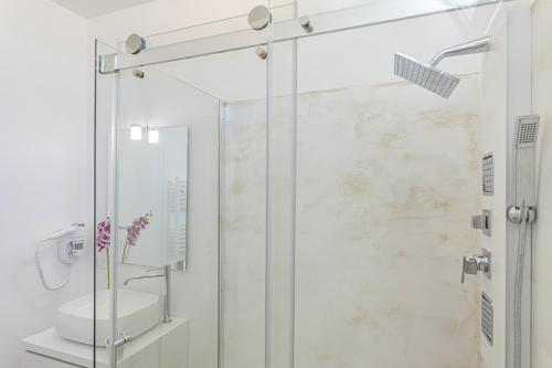 a bathroom with a shower with a toilet and a sink at Petra Bianca in Torre San Giovanni Ugento