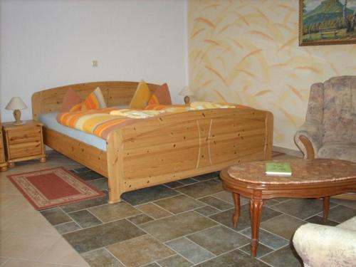 1 dormitorio con cama de madera y mesa en Ferienhaus am Malerweg, en Königstein