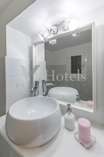a white bathroom with a sink and a mirror at AYZ Juan de Mena - Auto check-in property in Madrid